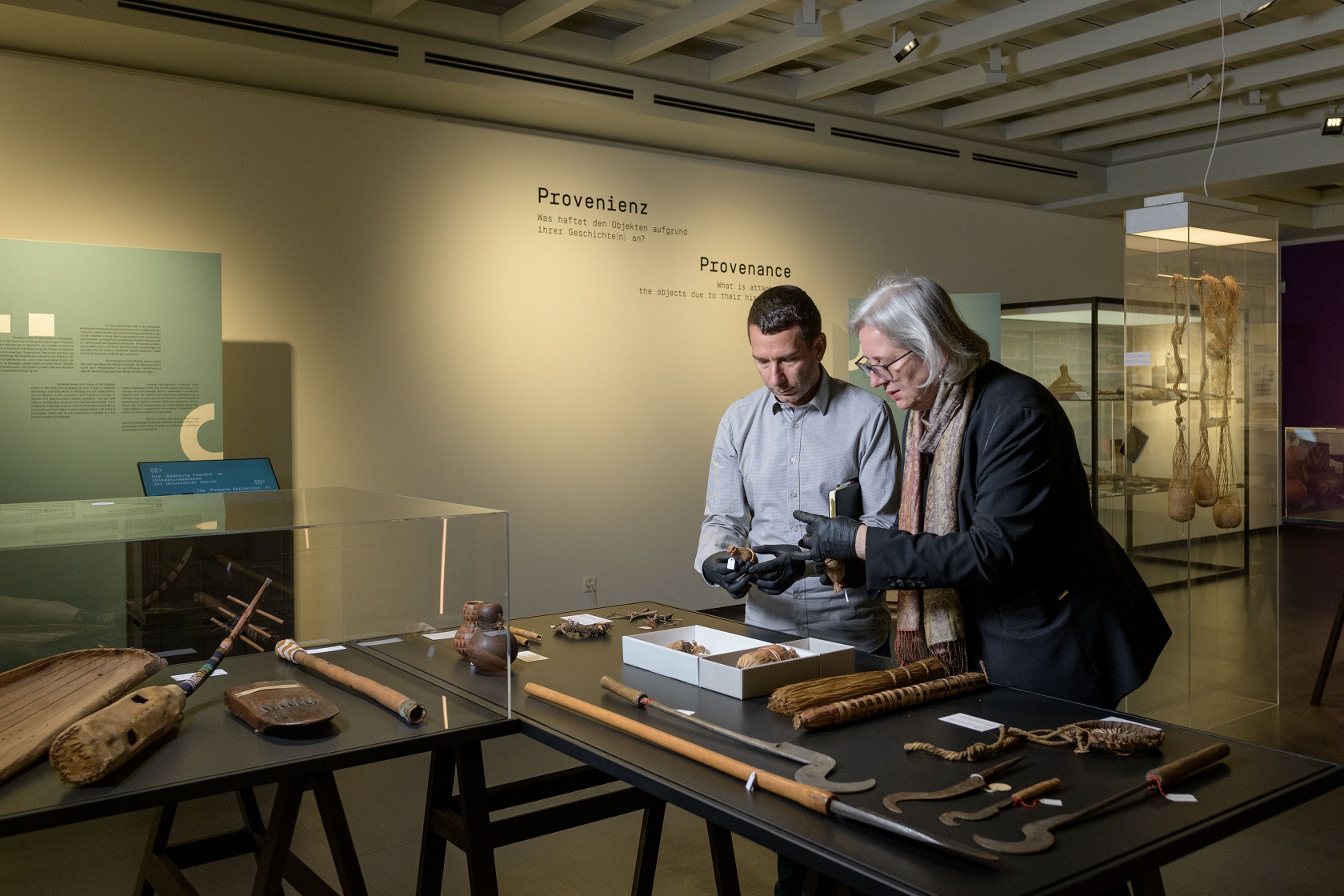 Kurator Alexis Malefakis und die Direktorin des Völkerkundemuseums Mareile Flitsch begutachten eine Harzfackel aus Rwanda.