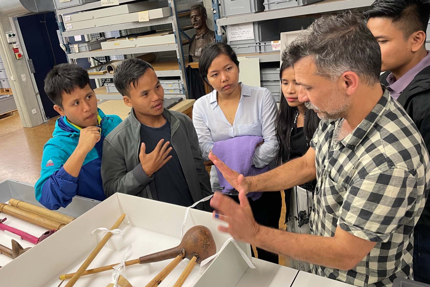 Die Studierenden aus den Chittagong Hill Tracts – Ralong Khumi, Thongpong Mro, Zing Ruat Par Bawm, Zoneikim Pangkhua und U Shamong Kheyang – diskutieren mit Restaurator Robert Tobler eine Mundorgel in der Sammlung des Museums.